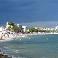 Sandy beach and yellow parasols at Plage du Soleil in Golfe-Juan